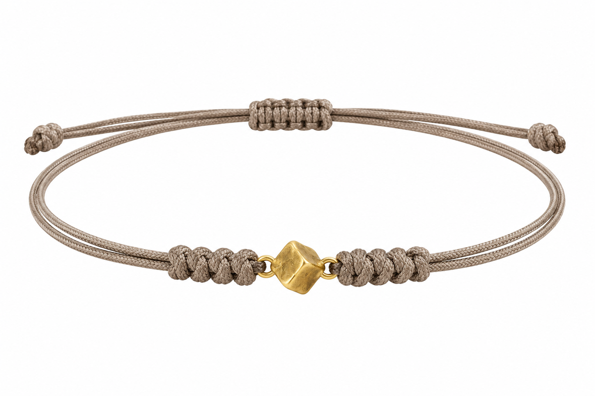Pulsera de cordón en tono topo con nudos de macramé y eslabón central en forma de cubo en oro de 18K