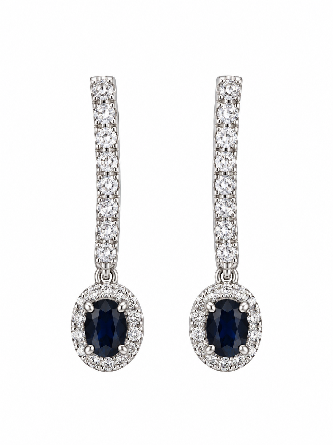 Pendientes largos de oro blanco con línea de diamantes y zafiros ovalados azules rodeados de un halo de diamantes